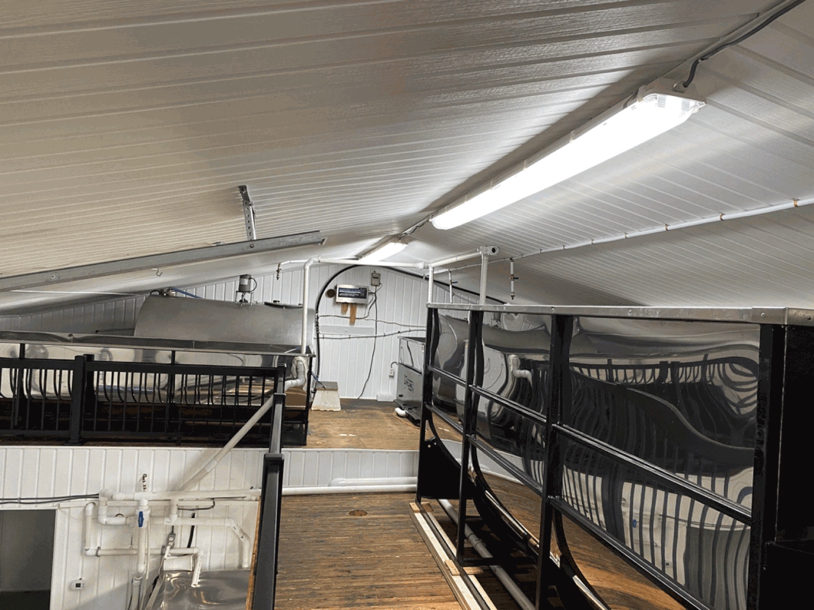 Mezzanine et passerelle de bois au-dessus des bassins d'une érablière, structure d'acier