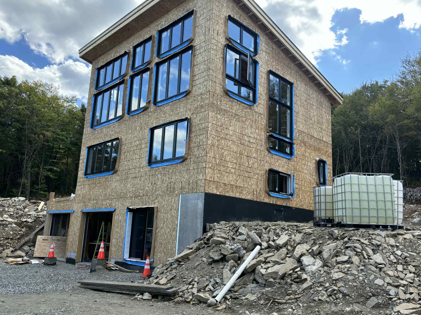 Bâtiment commercial moderne à plusieurs étages en construction, structure de bois et grandes fenêtres